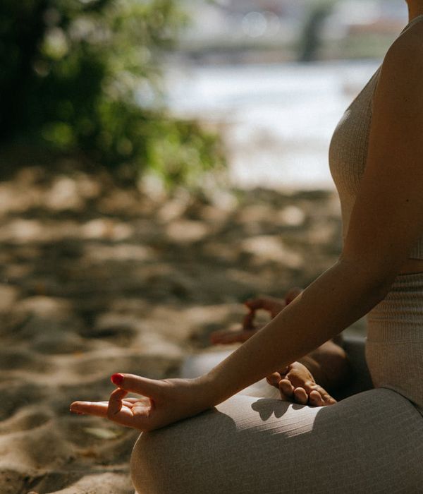 Person meditating in a calm and serene natural environment.